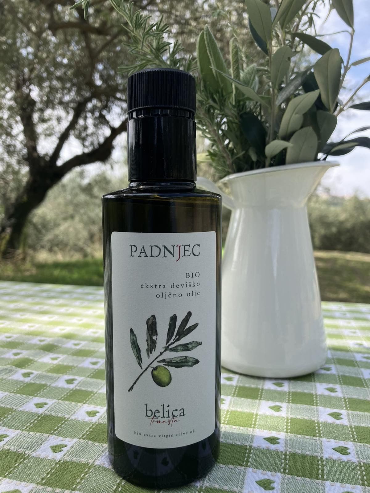 Bottle of Padnjec olive oil among olive branches